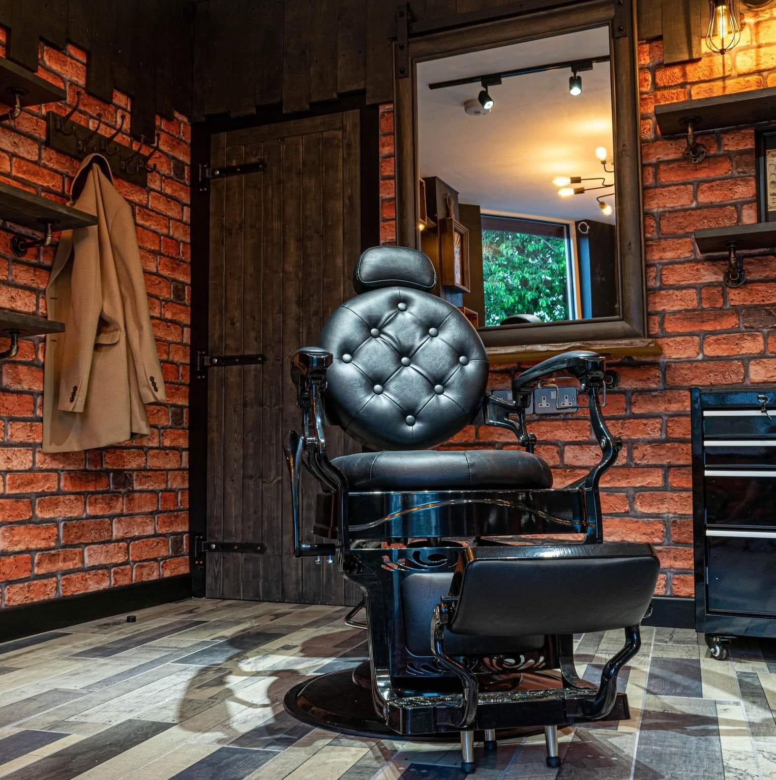 A black leather barber chair against the brick wall